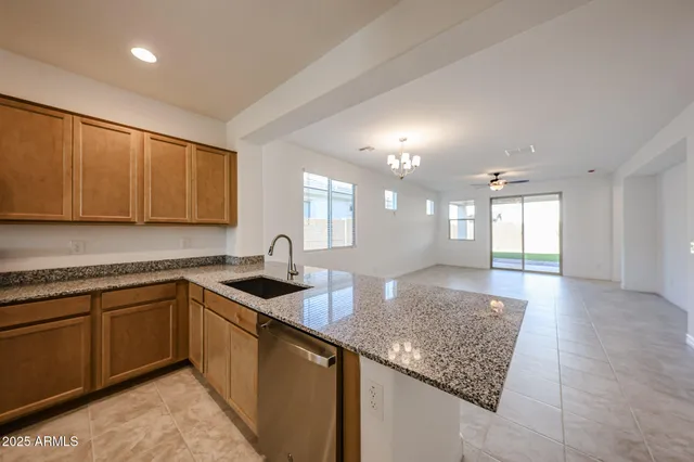 a kitchen with granite countertop a sink a stove cabinets and counter space