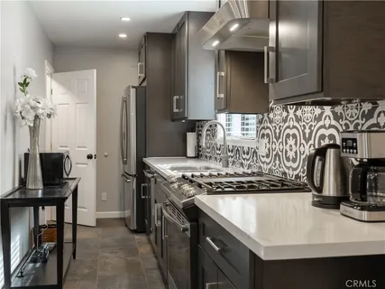 a kitchen with stainless steel appliances granite countertop a sink a stove and a refrigerator