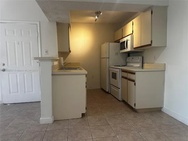 a kitchen with a stove top oven and cabinets