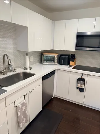 a kitchen with white cabinets sink and white appliances