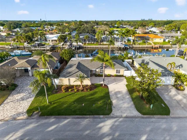 an aerial view of residential houses with outdoor space and trees