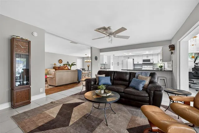 a living room with furniture a rug and kitchen view