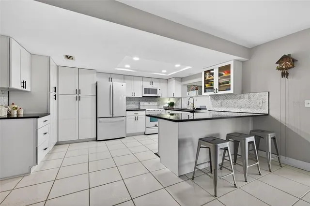 a kitchen with cabinets and chairs