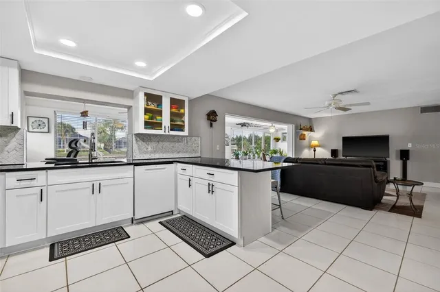 a kitchen with stainless steel appliances kitchen island granite countertop a refrigerator and a sink