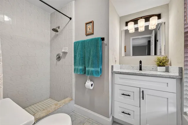a bathroom with a granite countertop sink toilet and shower