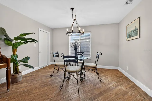 a dining room with furniture potted plants and wooden floor