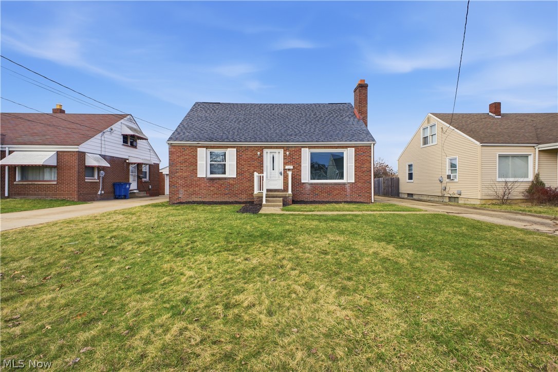 227 Wilson Street Struthers, OH 44471 - Photo 43 of 44 View of front facade with a chimney, brick siding, and a shingled roof