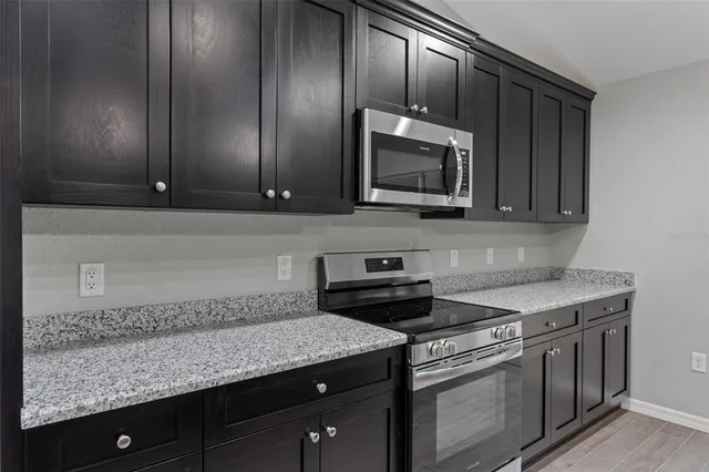 a kitchen with stainless steel appliances granite countertop a sink stove and microwave
