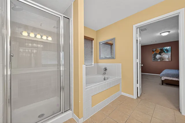a en suite bathroom with a tub shower and mirror