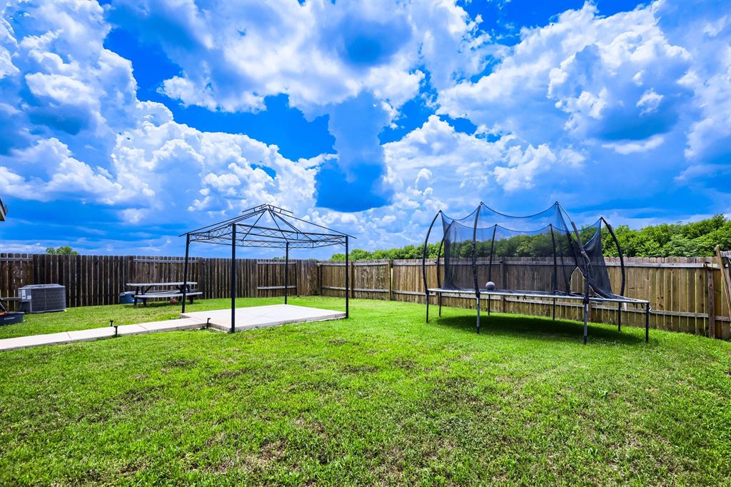 4309 Cat Tail Way Forney, TX 75126 - Photo 29 of 30 Expansive backyard featuring a lush lawn, concrete patio, and privacy fencing