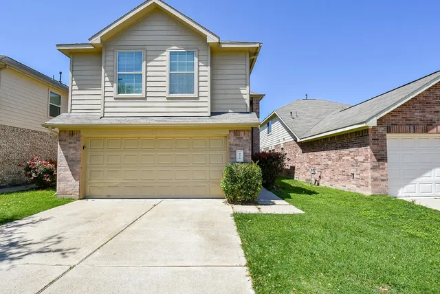 a front view of a house with a yard and garage