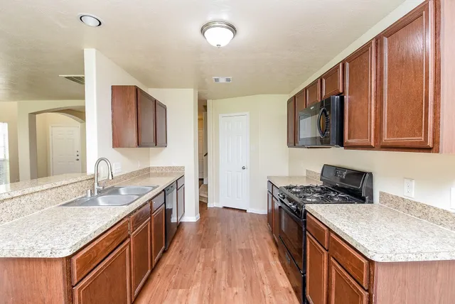 a kitchen with stainless steel appliances granite countertop a sink stove and cabinets