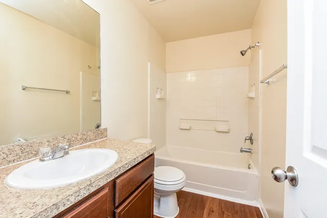 a bathroom with a granite countertop sink toilet and shower