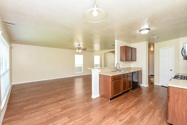 a large kitchen with cabinets wooden floor and stainless steel appliances