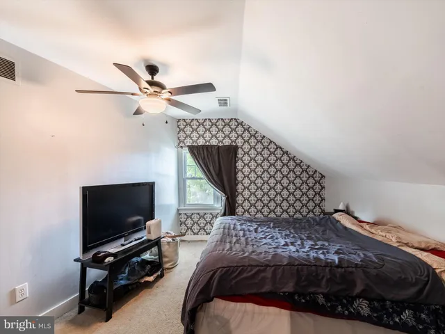 a bedroom with a bed window and a flat screen tv