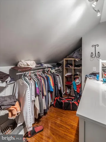 a view of walk in closet with clothes and shoes