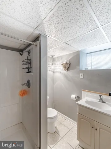 a bathroom with a granite countertop sink a toilet and shower