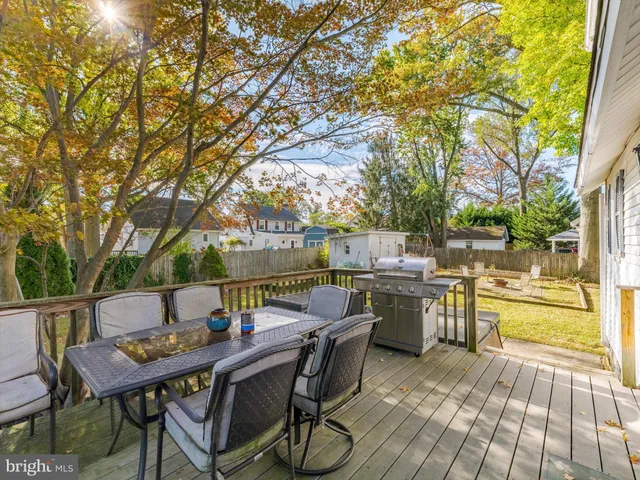 a view of a patio with a dining table and chairs with wooden floor and fence