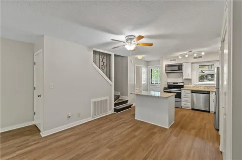 a view of kitchen with wooden floor and electronic appliances
