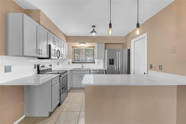a large kitchen with kitchen island a sink stainless steel appliances and cabinets