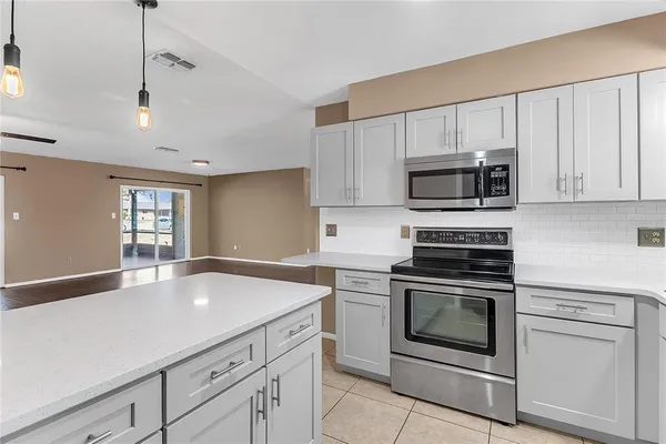 a kitchen with granite countertop a stove microwave and sink