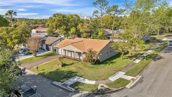 an aerial view of a house with swimming pool and large trees