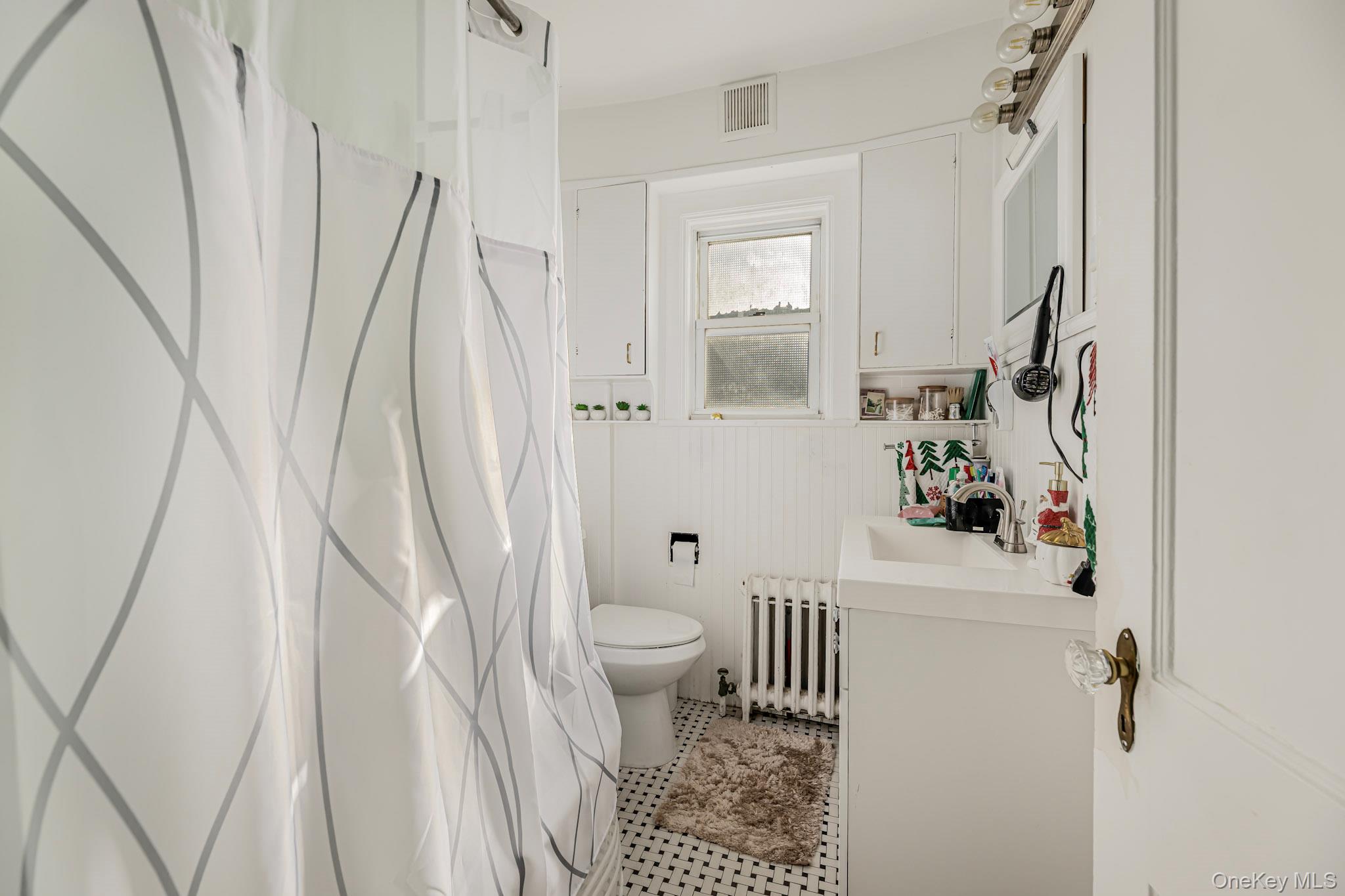 168 Stephenson Boulevard New Rochelle, NY 10801 - Photo 21 of 21 Full bathroom with vanity, radiator heating unit, a shower with curtain, and light tile patterned flooring