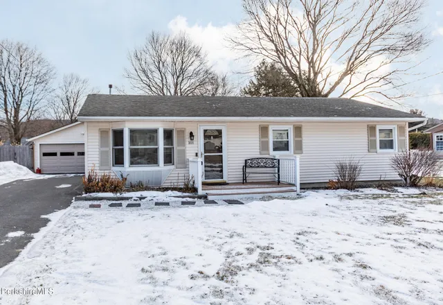 a front view of a house with yard covered in snow