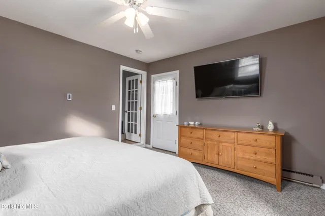 a bedroom with a large bed and a flat screen tv