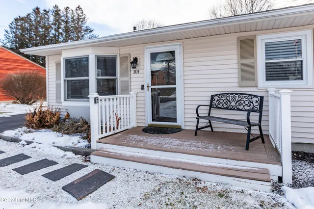a view of a house with a bench in front of house