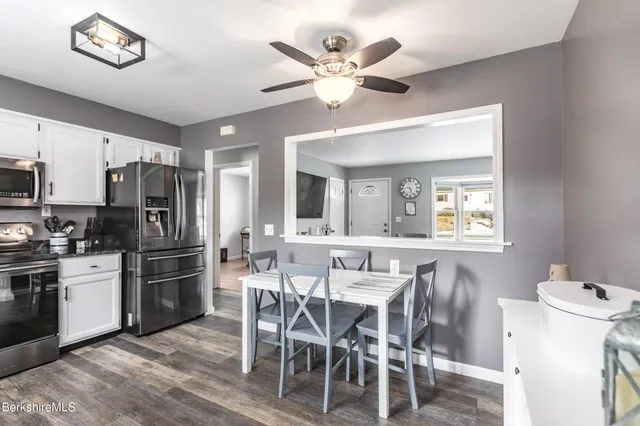 a kitchen with a dining table chairs and refrigerator