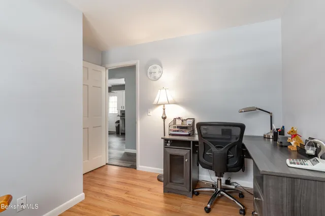 a view of a workspace with furniture and wooden floor