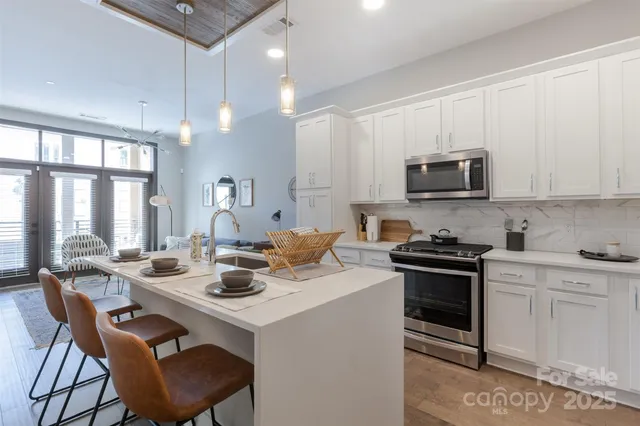 a kitchen with a stove a sink a dining table and chairs