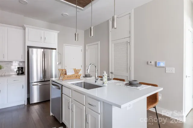 a kitchen with stainless steel appliances a sink and a refrigerator