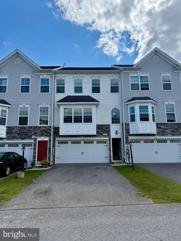 a view of a house with a yard and a car parked in front of it