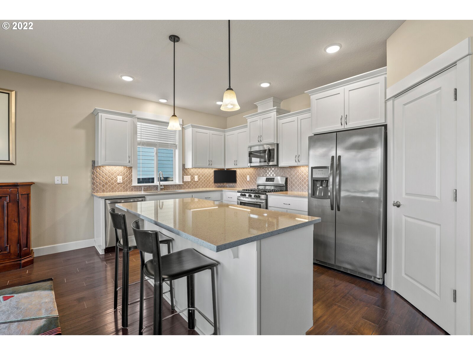 1704 Northeast 172nd Street Ridgefield, WA 98642 - Photo 10 of 31 a kitchen with stainless steel appliances kitchen island a table chairs in it and wooden floors