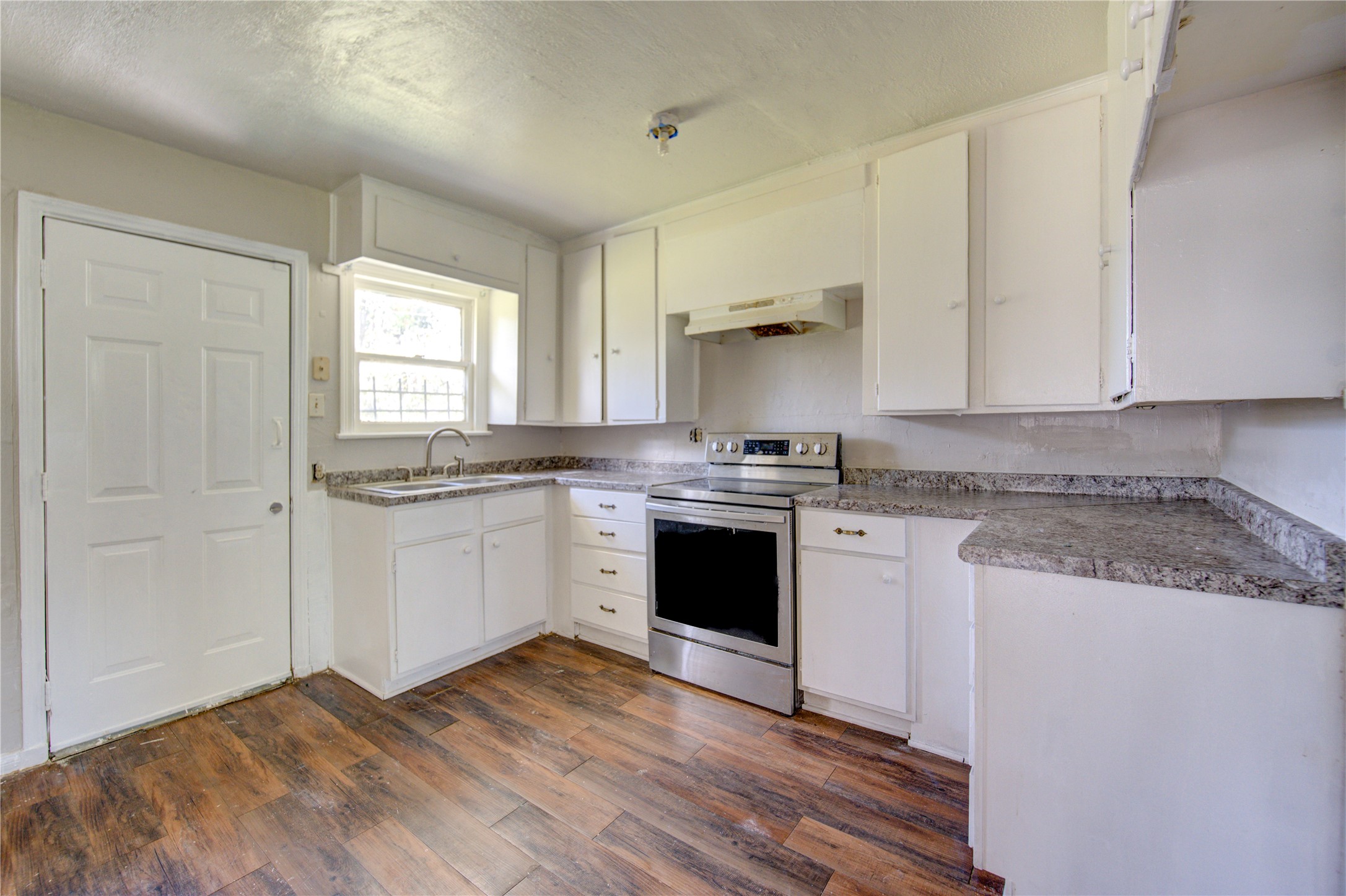 3431 Sayers Street Houston, TX 77026 - Photo 13 of 44 a kitchen with granite countertop white cabinets and white appliances