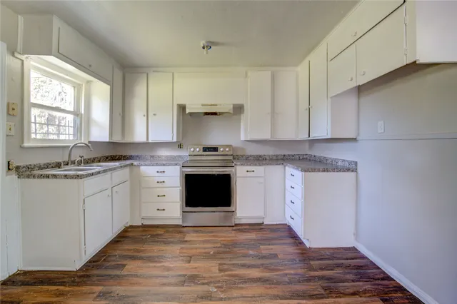 a kitchen with granite countertop white cabinets and white appliances
