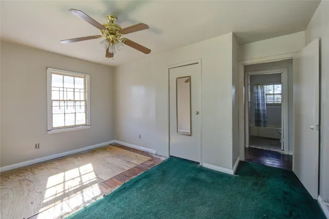 an empty room with fan and windows