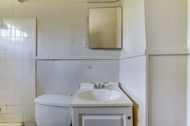 a bathroom with a sink a toilet and mirror