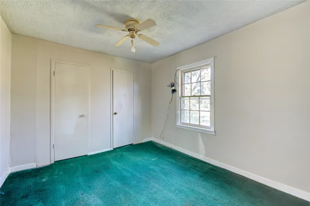 an empty room with a chandelier fan