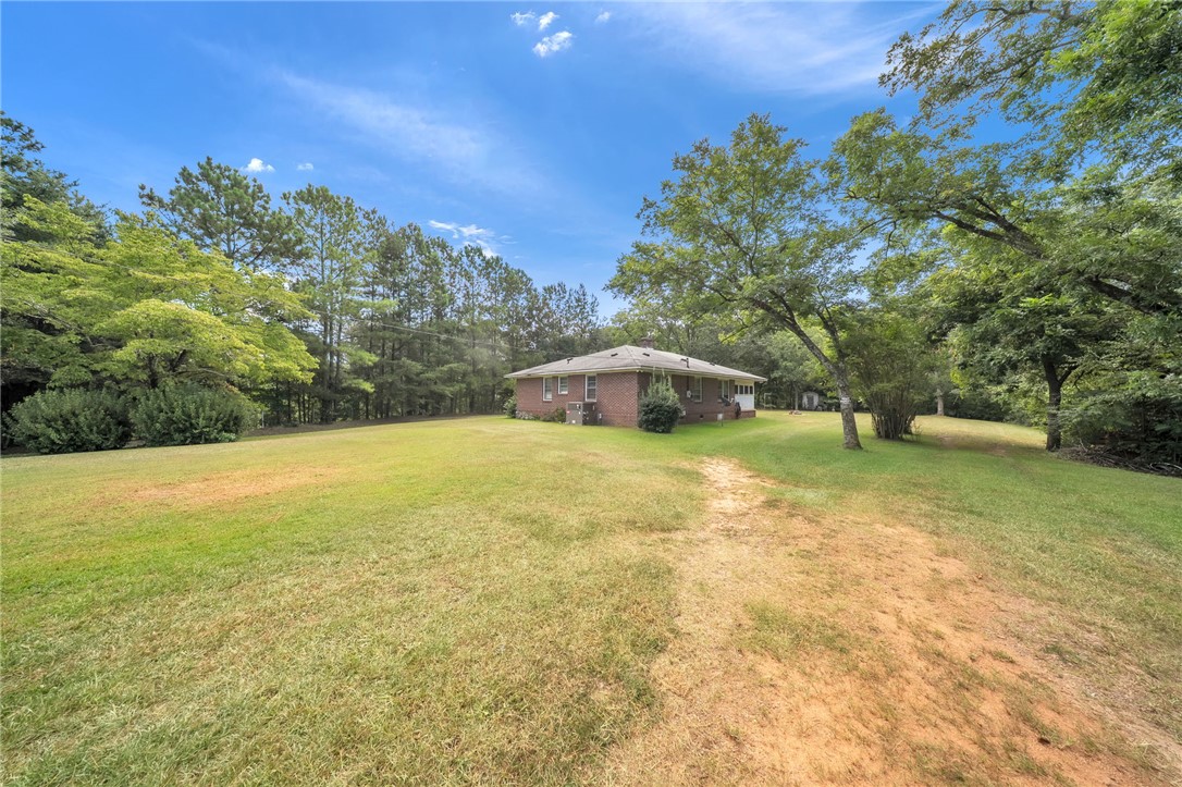 107 Burton Road Anderson, SC 29625 - Photo 24 of 33 Mature trees frame a sprawling grassy lawn surrounding the brick residence.