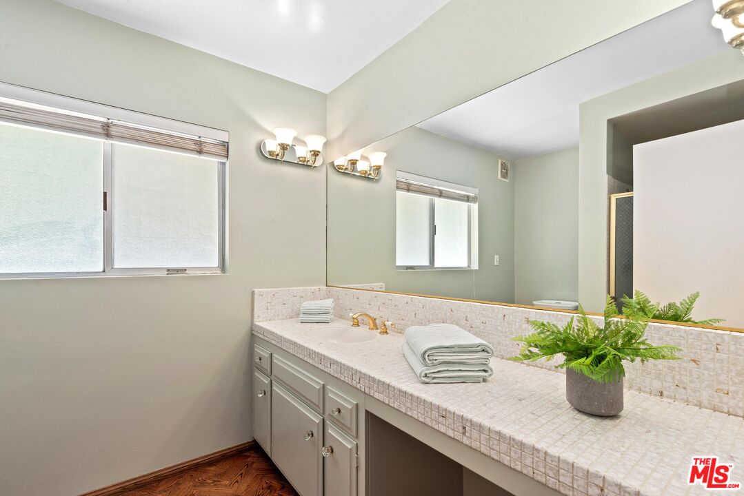 8636 Edwin Drive Los Angeles, CA 90046 - Photo 10 of 25 a bathroom with a granite countertop sink a mirror and a shower
