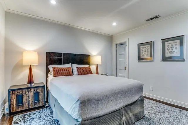 a bedroom with a bed a mirror and lamp