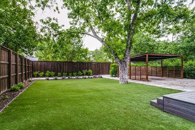 a view of a backyard with table and chairs and wooden fence