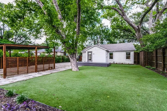 a front view of a house with a garden and yard
