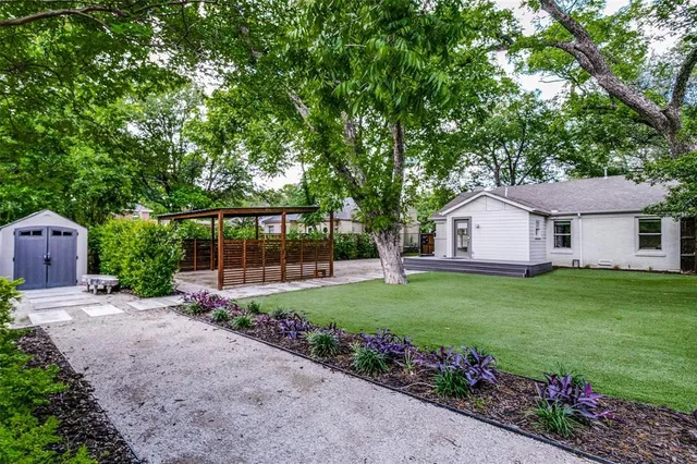a front view of a house with a big yard and potted plants