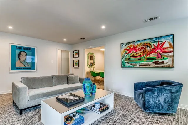 a living room with furniture and wall paintings