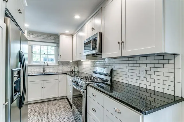 a kitchen with granite countertop a sink stove and cabinets
