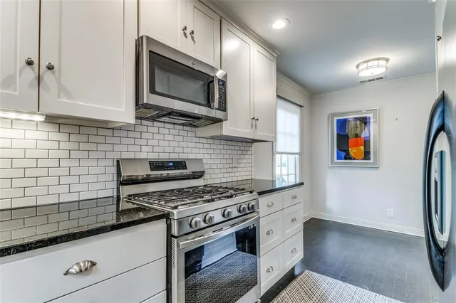 a kitchen with stainless steel appliances a stove microwave and refrigerator